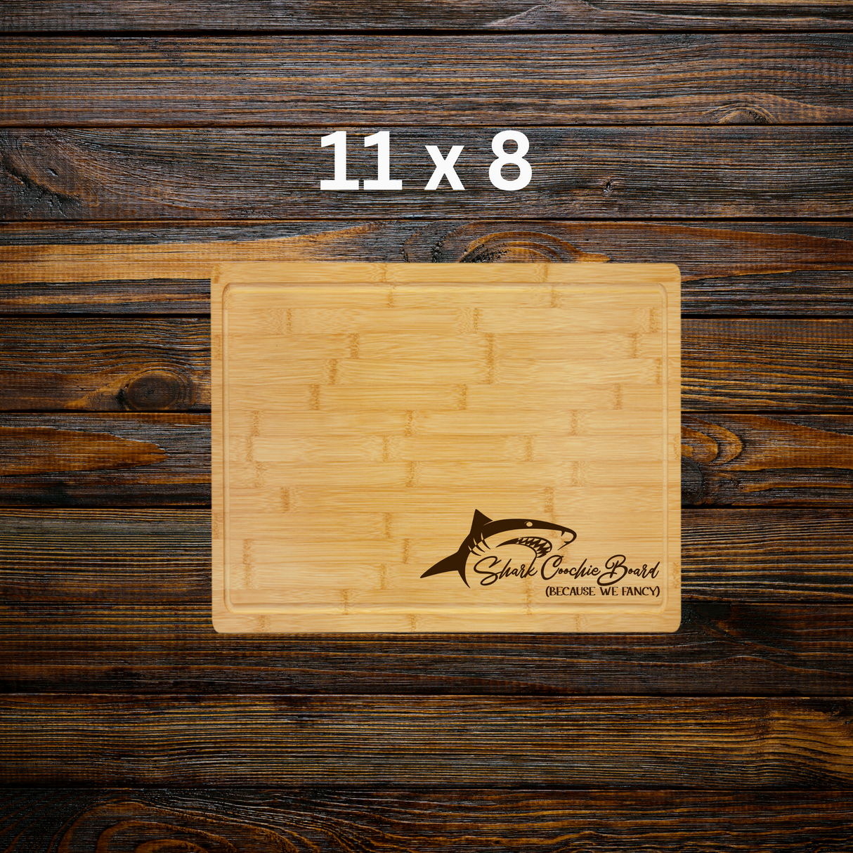 Wooden cutting board with shark design and text on a wooden background