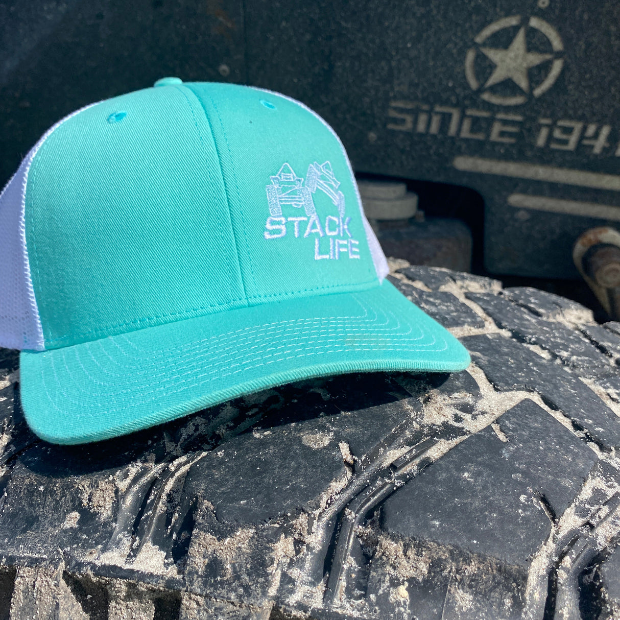 teal stack life trucker hat with white logo