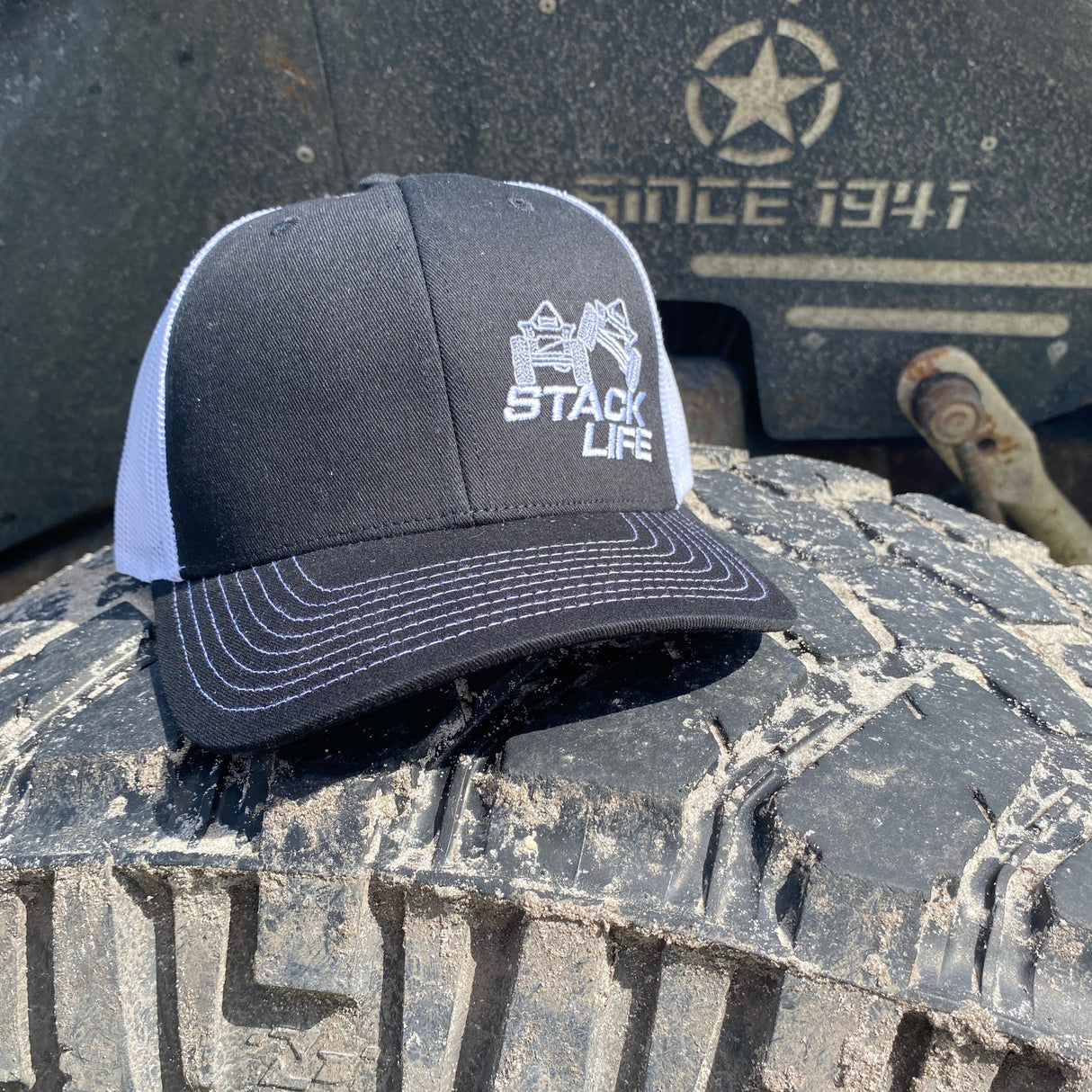 black and white stack life trucker hat with white logo