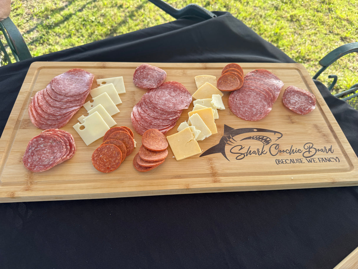 photograph of wooden board with sharkcoochie on the corner with meats and cheeses on it