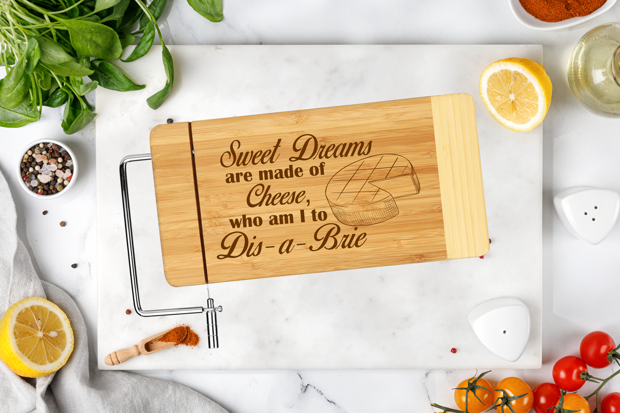 Image of cheese board with slicer that has Sweet Dreams are made of cheese, who am I to dis-a-brie