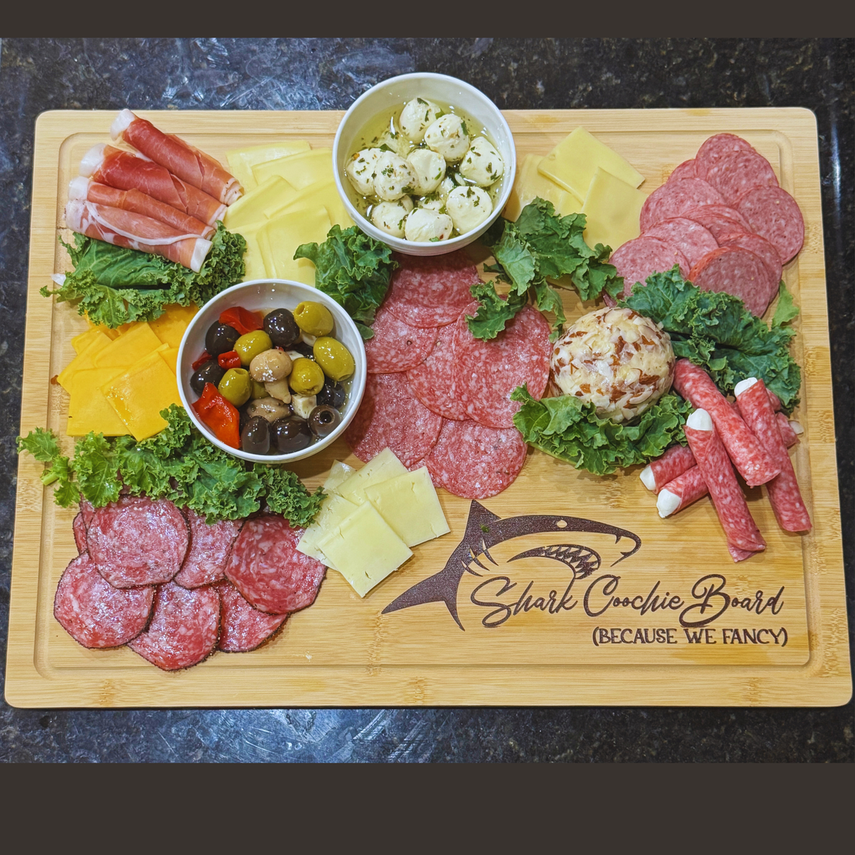 Wooden charcuterie board with various meats, cheeses, and olives on a dark surface.