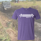 Purple t-shirt with white 7 tire design and mermaids on each side graphic design on a background of an off-road vehicle in a field.