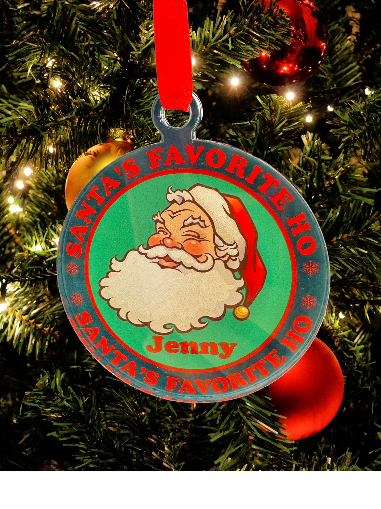 
Vintage-style acrylic Christmas ornament featuring a winking Santa, the text "Santa's Favorite Ho," and a customizable name in festive colors, hanging on a tree.