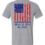 Light grey t shirts with american flag on the back running vertical down back.  At the bottom of the flag is a stack of 7 off road vehicles with the words Stackin' to honor the fallen underneath