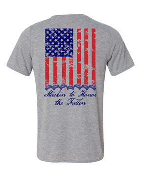 Light grey t shirts with american flag on the back running vertical down back.  At the bottom of the flag is a stack of 7 off road vehicles with the words Stackin' to honor the fallen underneath
