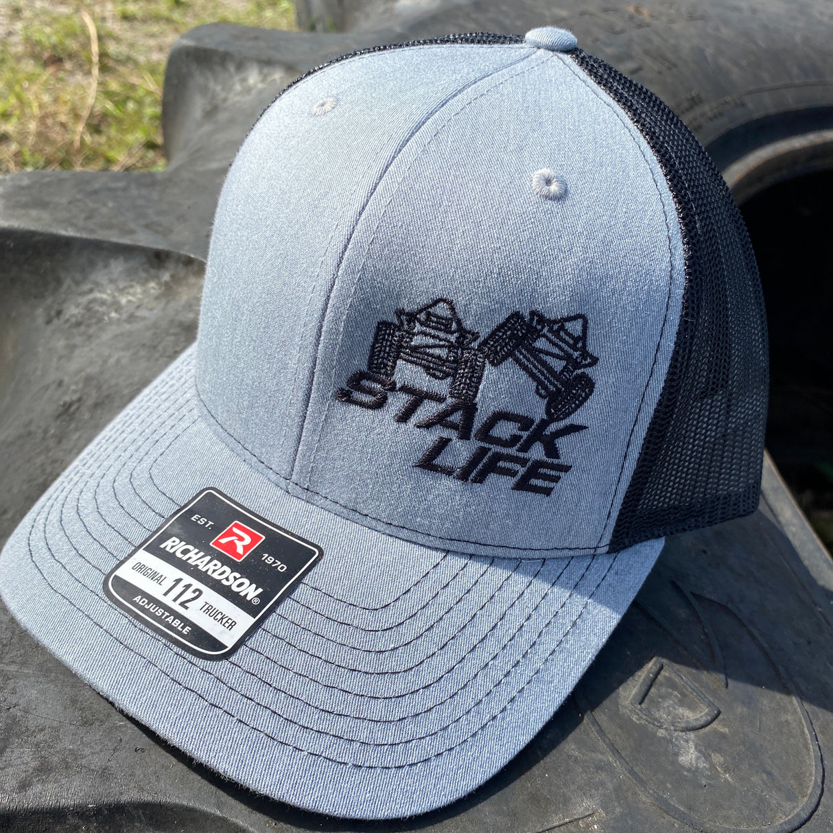 grey and black stack life trucker hat with black logo