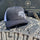 black and white stack life trucker hat with white logo