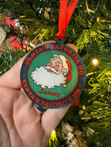 Vintage-style acrylic Christmas ornament featuring a winking Santa, the text "Santa's Favorite Ho," and a customizable name in festive colors, hanging on a tree.