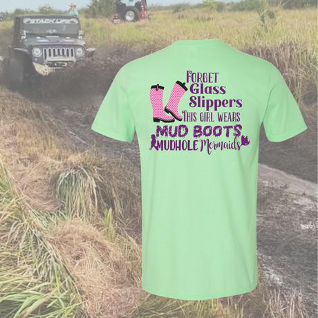 Mint t-shirt with text and pink boots graphic in a muddy field with a jeep.