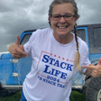 Person wearing a 'Stack Life 2024' t-shirt in front of a blue truck.
