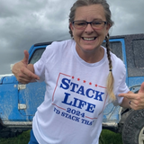 Person wearing a 'Stack Life 2024' t-shirt in front of a blue truck.